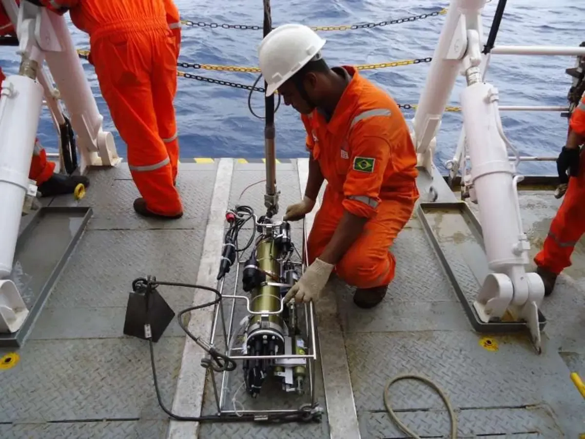 Técnico preparando instrumento oceanográfico no convés de embarcação
