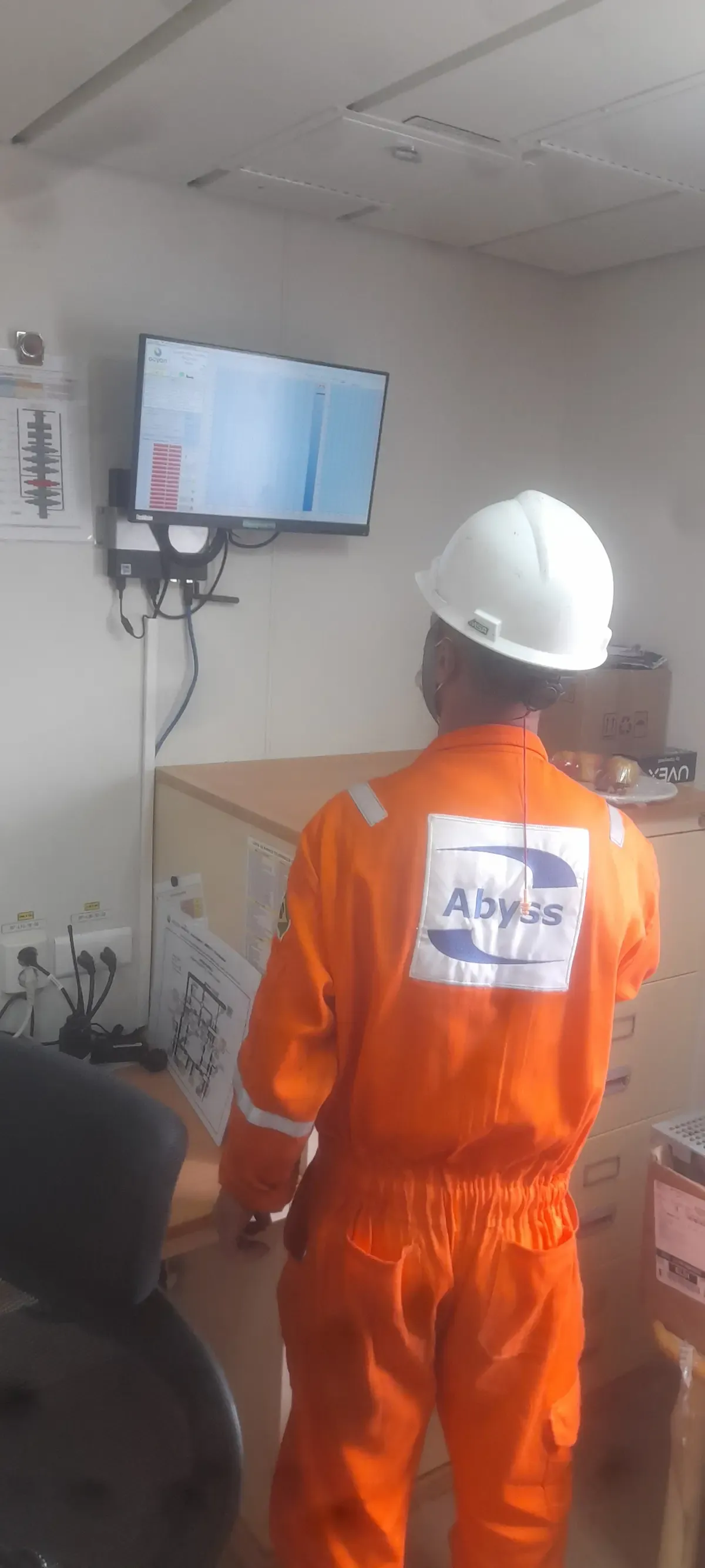 Bancada de testes com monitor no laboratório da Abyss